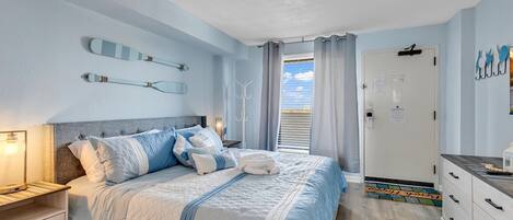 A bedroom with a bed, bedside tables, a wardrobe, and a door leading to a balcony.