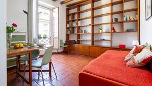 A cozy room with a wooden desk, a comfortable bed, and a large bookshelf filled with books and decorative items. - Dockside Studio (Milano)
