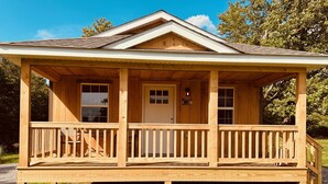 A wooden cabin with a porch, a front door, and a small staircase leading up to the entrance. - Cozy Cabin Boarding Winslow Hill Elk Viewing Area! (Benezette)