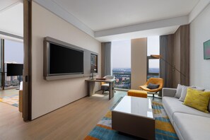 A modern hotel room with a large flat-screen TV, a comfortable sofa, a desk with a chair, and a view of the cityscape through large windows. - Hotel Plume Chengdu, Tapestry Collection By Hilton (Chengdu)