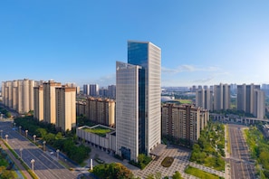 A high-rise hotel with a modern glass facade, surrounded by other residential buildings. - Hotel Plume Chengdu, Tapestry Collection By Hilton (Chengdu)