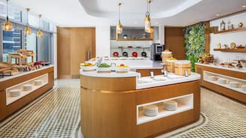 A modern kitchen with a central island, wooden cabinetry, and a checkered floor pattern.