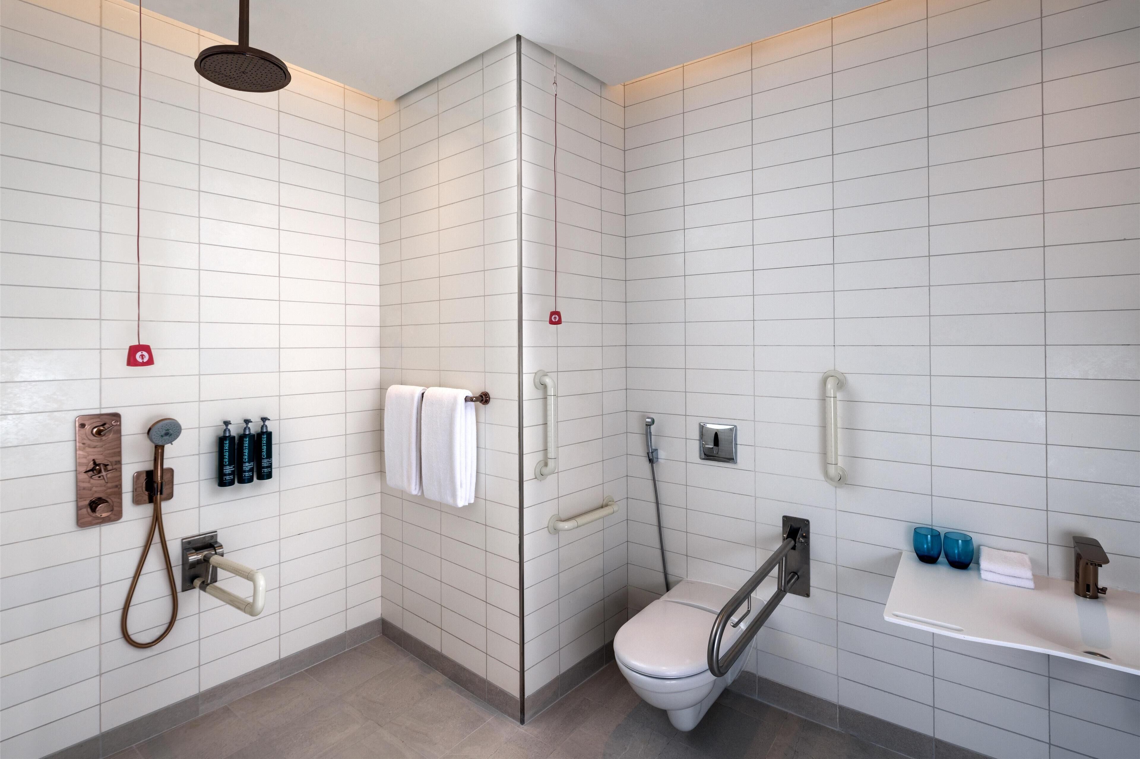 A modern bathroom with a shower, toilet, and sink.