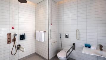 A modern bathroom with a shower, toilet, and sink.