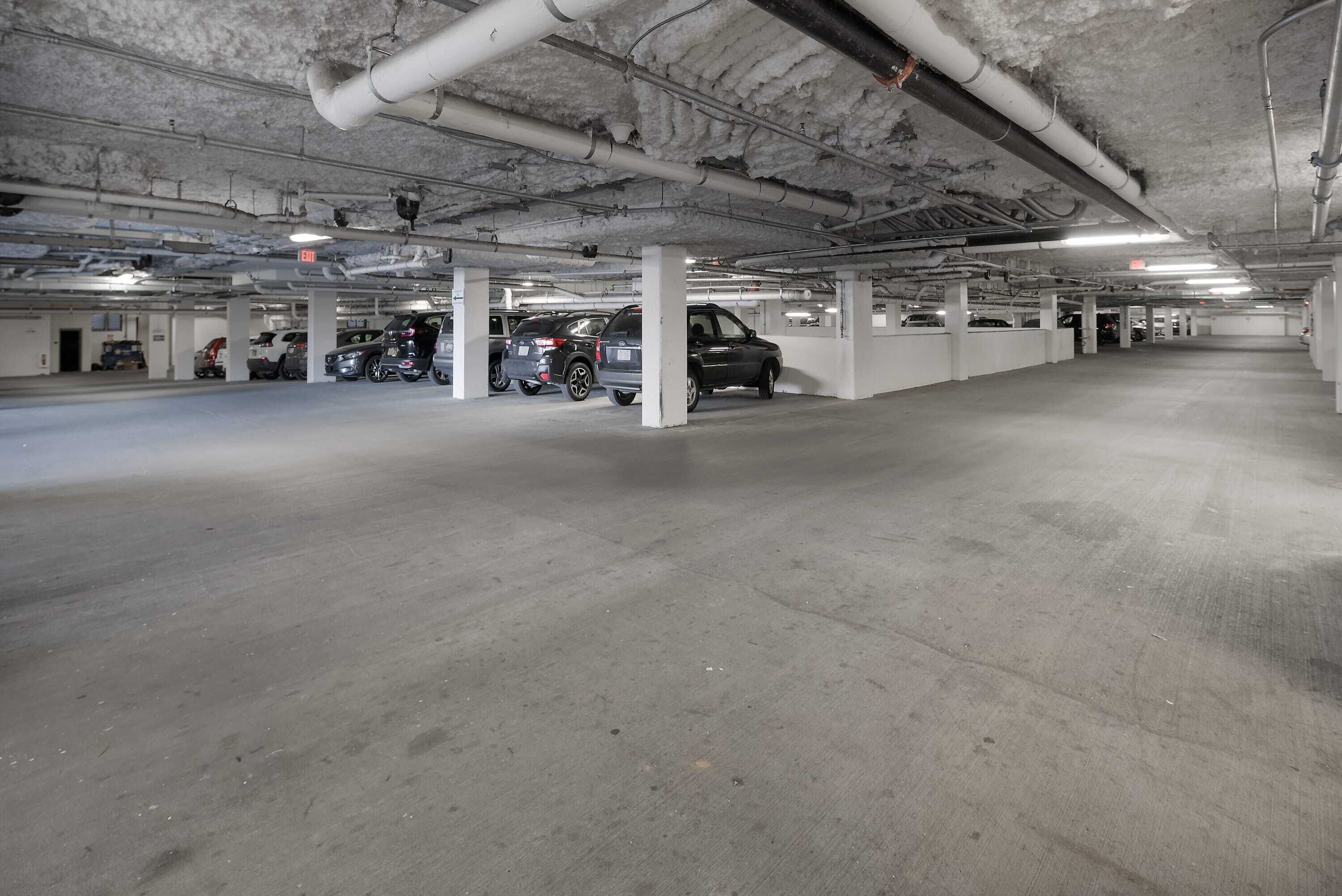 A multi-level parking garage with concrete floors and white pillars.