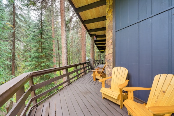 A wooden deck with Adirondack chairs overlooking a forest. - Mid-Century Cabin: Creekside, Easy Access to i-70 (Dumont)
