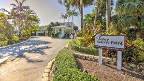 A sign for Key Colony Point with a view of a residential area and a curved road. - Classic & Comfortable Oceanfront Condo (Key Colony Beach)