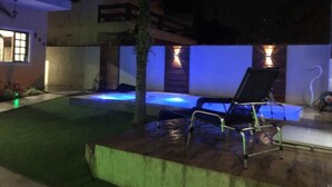 An outdoor pool area with a hot tub, a lounge chair, and a wooden deck. - Casa de Praia com Piscina Aquecida, ar Condicionado, Cervejeira e Bilhar!!! (Vista Linda Bertioga)
