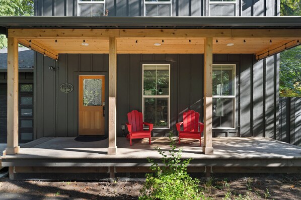 Morning coffee spot: covered porch seating just steps from the forest. - Luxury Cabin with Hot Tub, Fire Pit, Fireplace (Rhododendron)