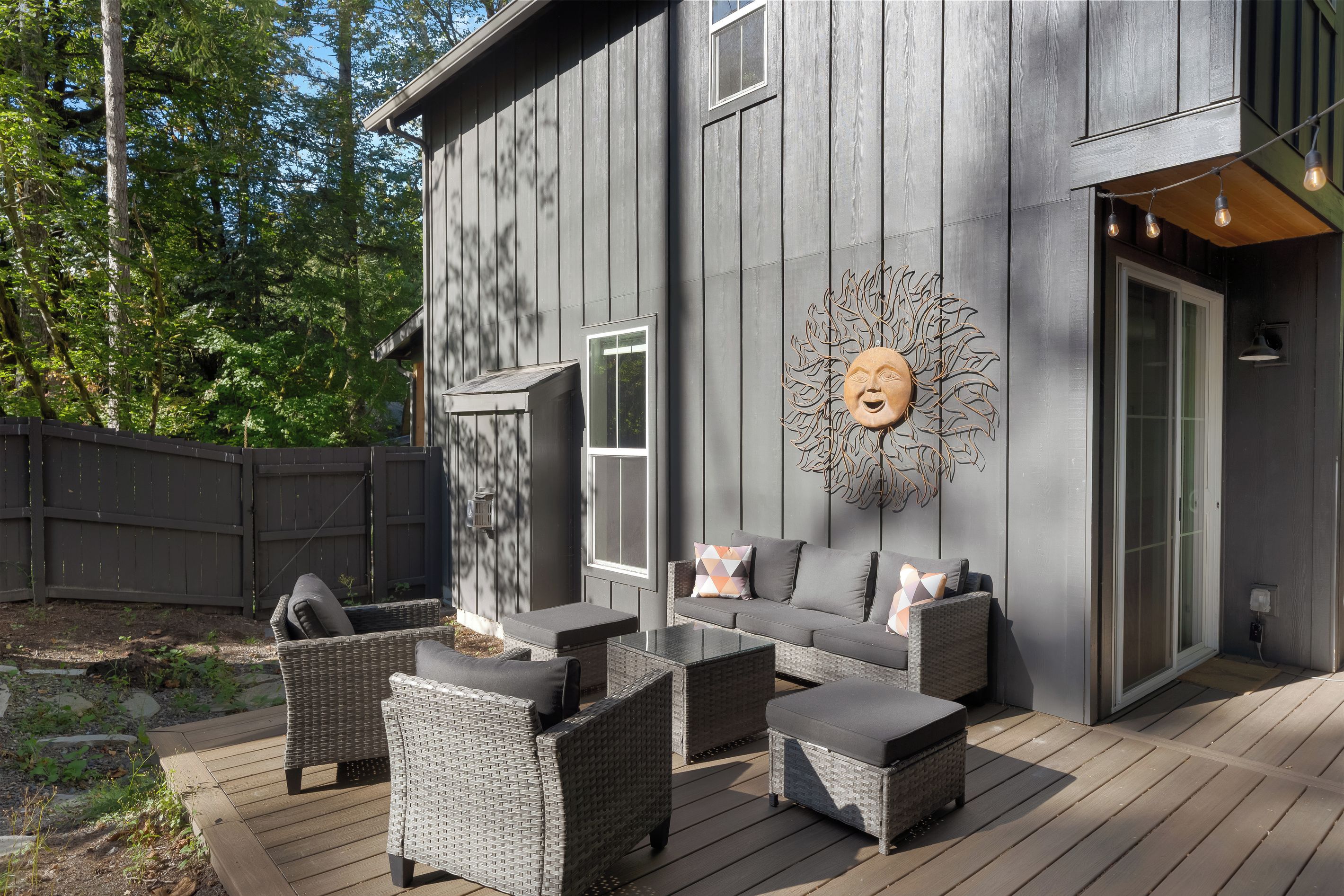 Une maison moderne dotée d’une terrasse, de mobilier d’extérieur et d’un élément décoratif mural.