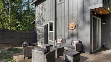 Une maison moderne dotée d’une terrasse, de mobilier d’extérieur et d’un élément décoratif mural.