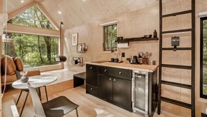 Una cocina moderna con armarios de madera, un refrigerador empotrado y una ventana con vistas a un bosque.