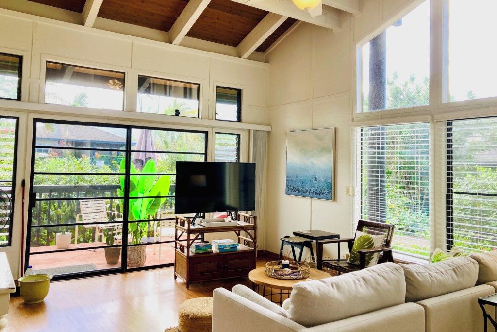 Un salón amplio con una televisión grande, asientos cómodos y vistas amplias a través de grandes ventanales.