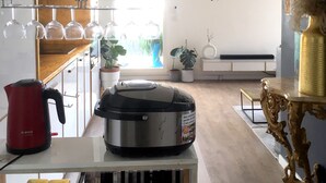 Una cocina moderna con una cafetera Bosch, una olla negra grande y varios vasos en estantes.