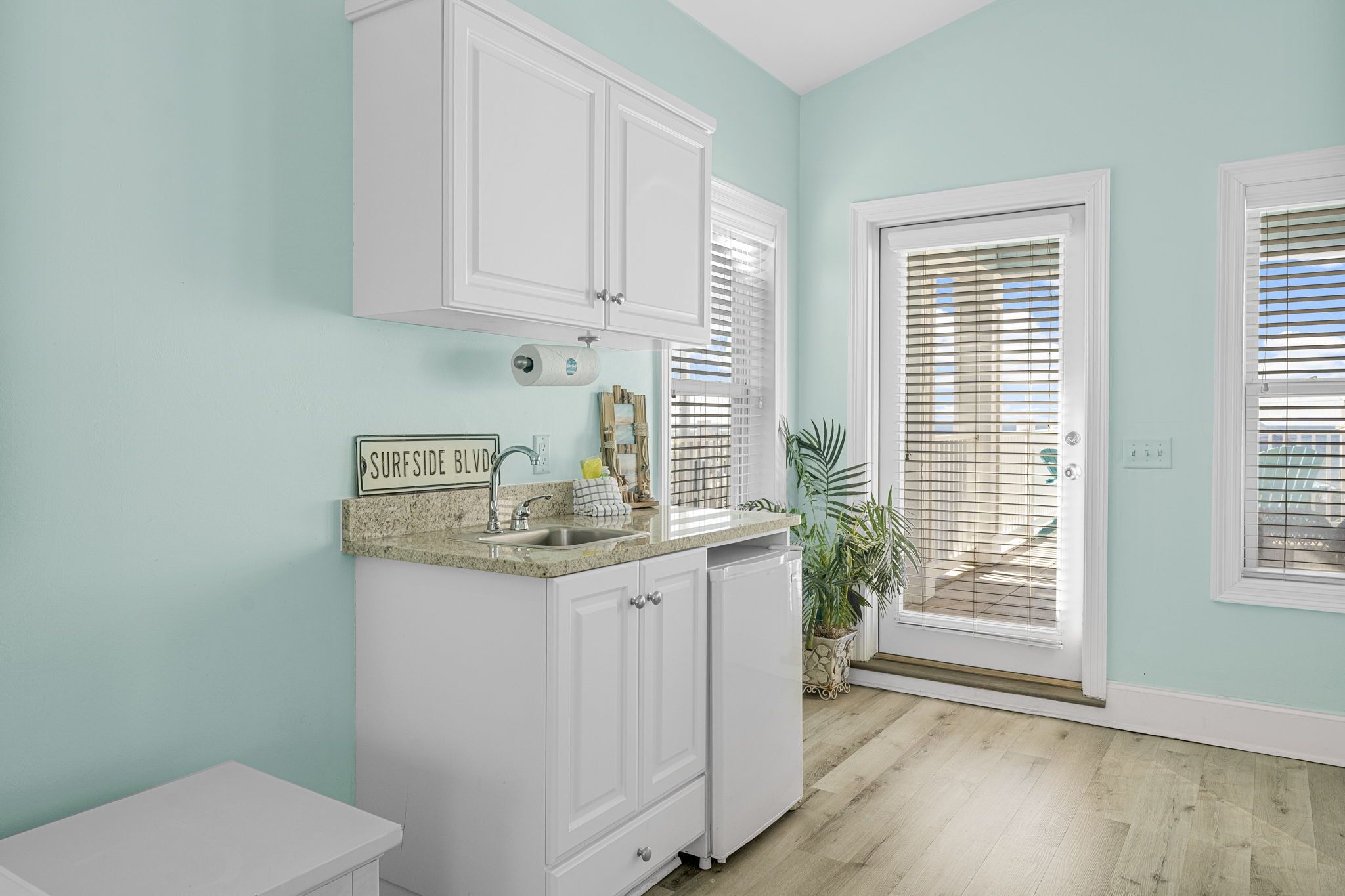 A kitchen with white cabinets, a granite countertop, and a sign that reads "SURFSIDE BLVD."