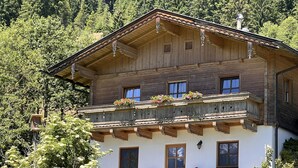A two-story wooden chalet with balconies, a wooden facade, and a white exterior. - Ferienhaus Taubenstein by Interhome (Neukirchen am Großvenediger)