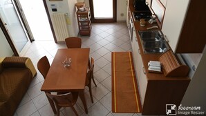 Een kleine keuken met een eethoek, een radiator en een raam.