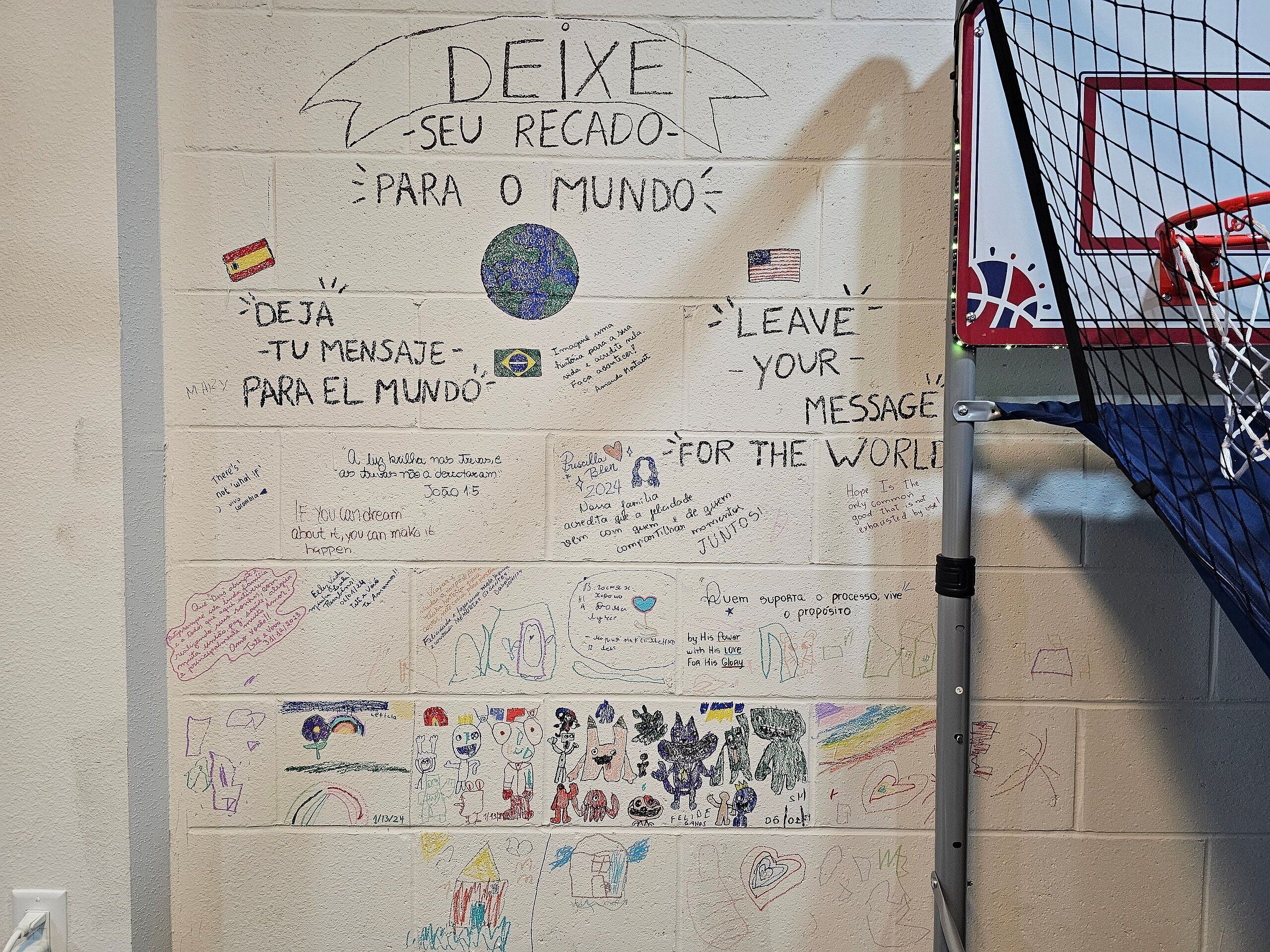 A wall with various messages and drawings, including a basketball hoop.