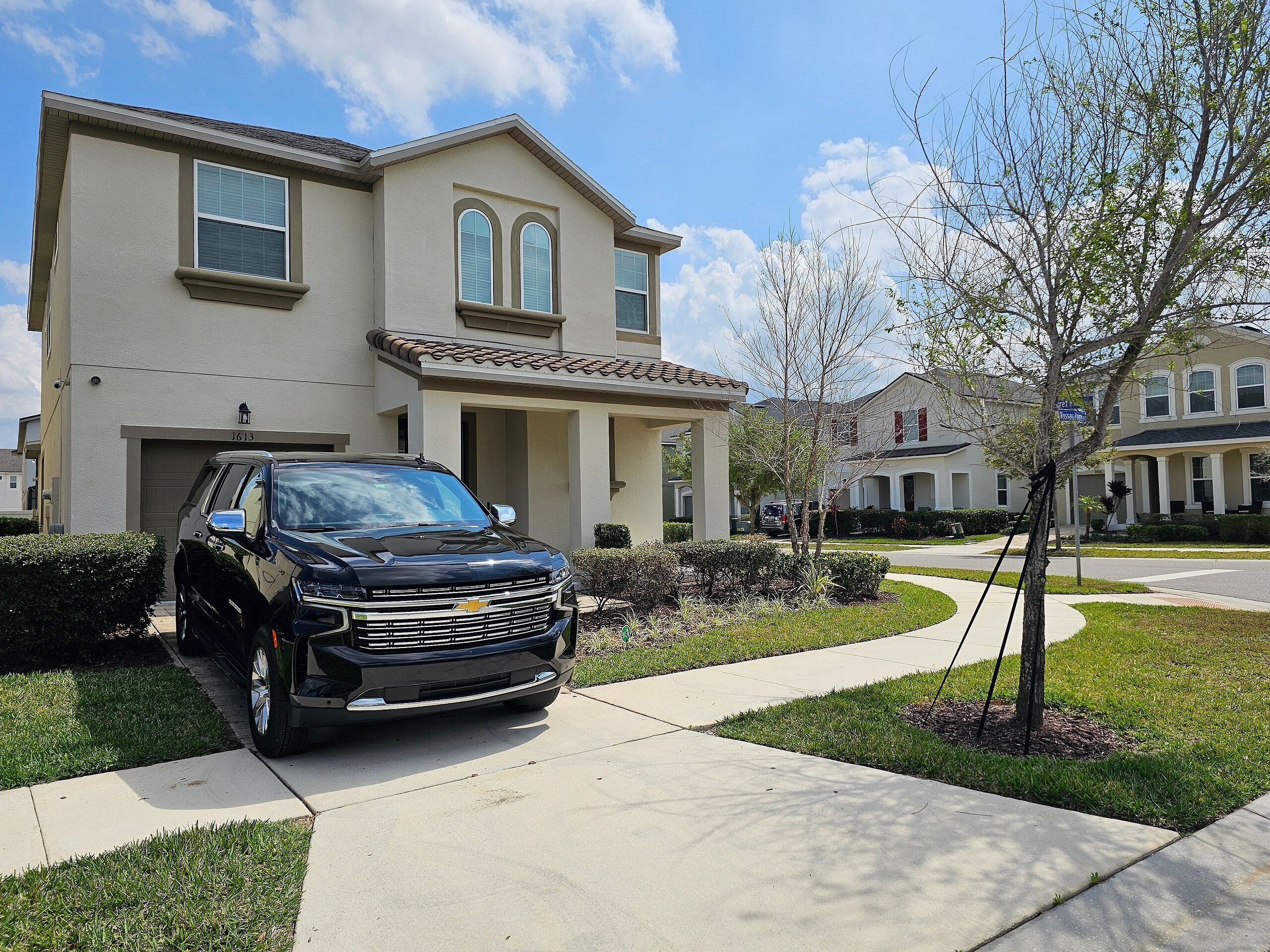 A residential house with a driveway and a parked SUV.