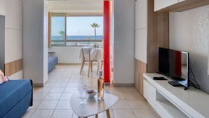 Ein modernes Hotelzimmer mit Balkon, Essbereich und Fernseher.