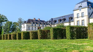 A large, multi-story building with a symmetrical facade, featuring a central tower and multiple windows. - Château De Kergonano, dans l'Orangerie by Interhome (Baden)