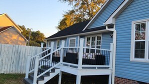 A blue house with a white porch and a wooden fence.