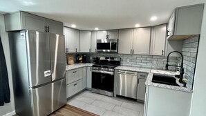Una cocina moderna con electrodomésticos de acero inoxidable, microondas y lavavajillas.