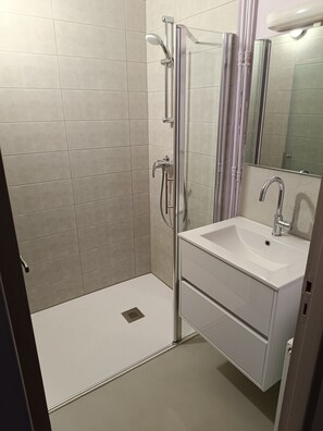 Quarto quádruplo conforto, várias camas | Banheiro | Chuveiro 