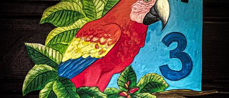 A colorful parrot decoration with a number '3' on a door.