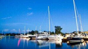 A marina with multiple sailboats docked at calm water. - River Runs Through It (Belleville)