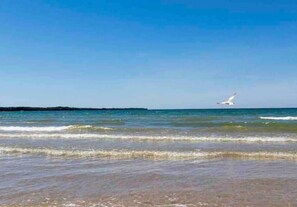 Una playa con cielos despejados y aguas tranquilas.