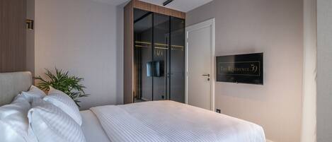 Un dormitorio moderno con una cama grande, un armario con espejo y un cartel que indica la habitación número 59.