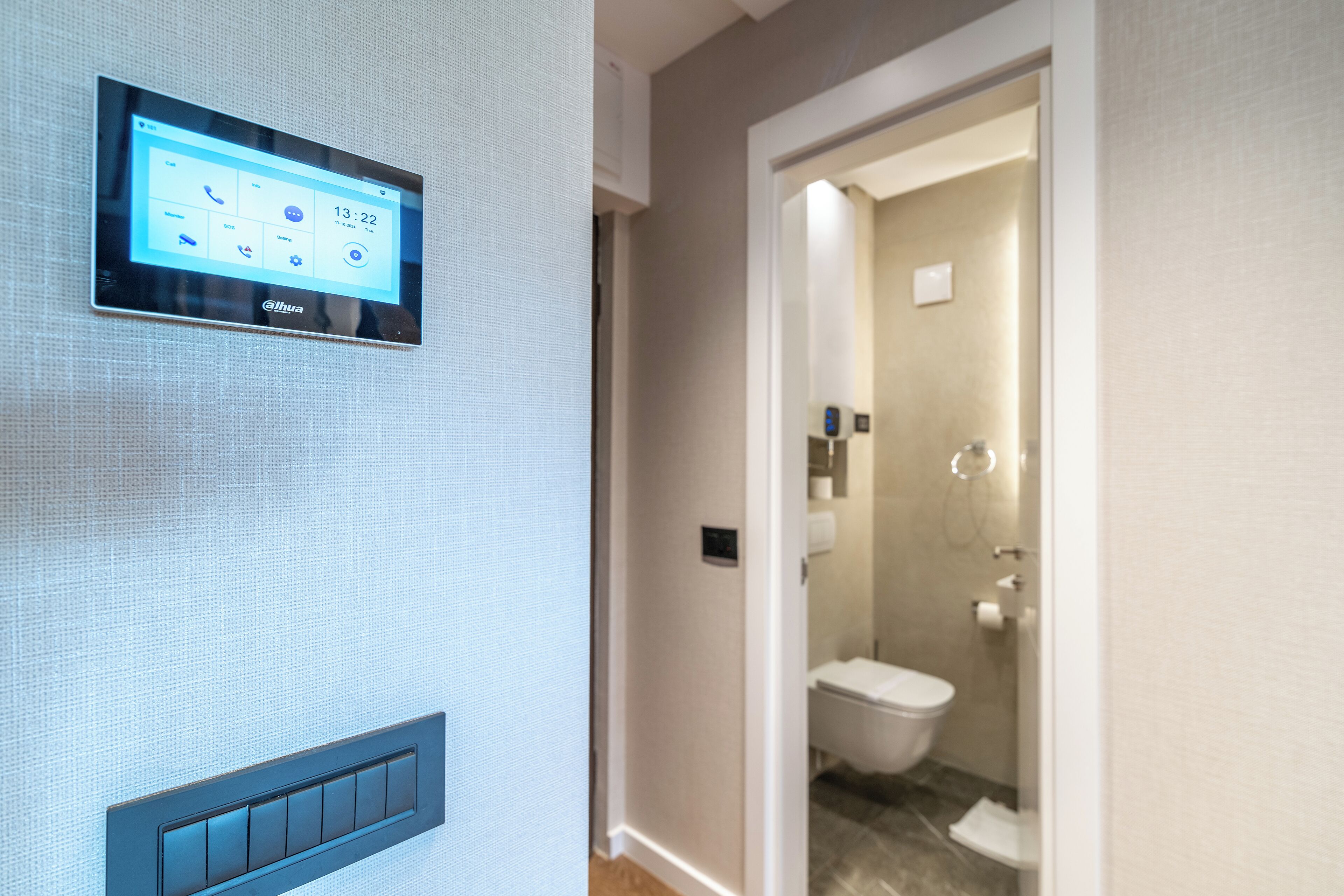 Et badeværelse med toilet, bruser og et panel på væggen.