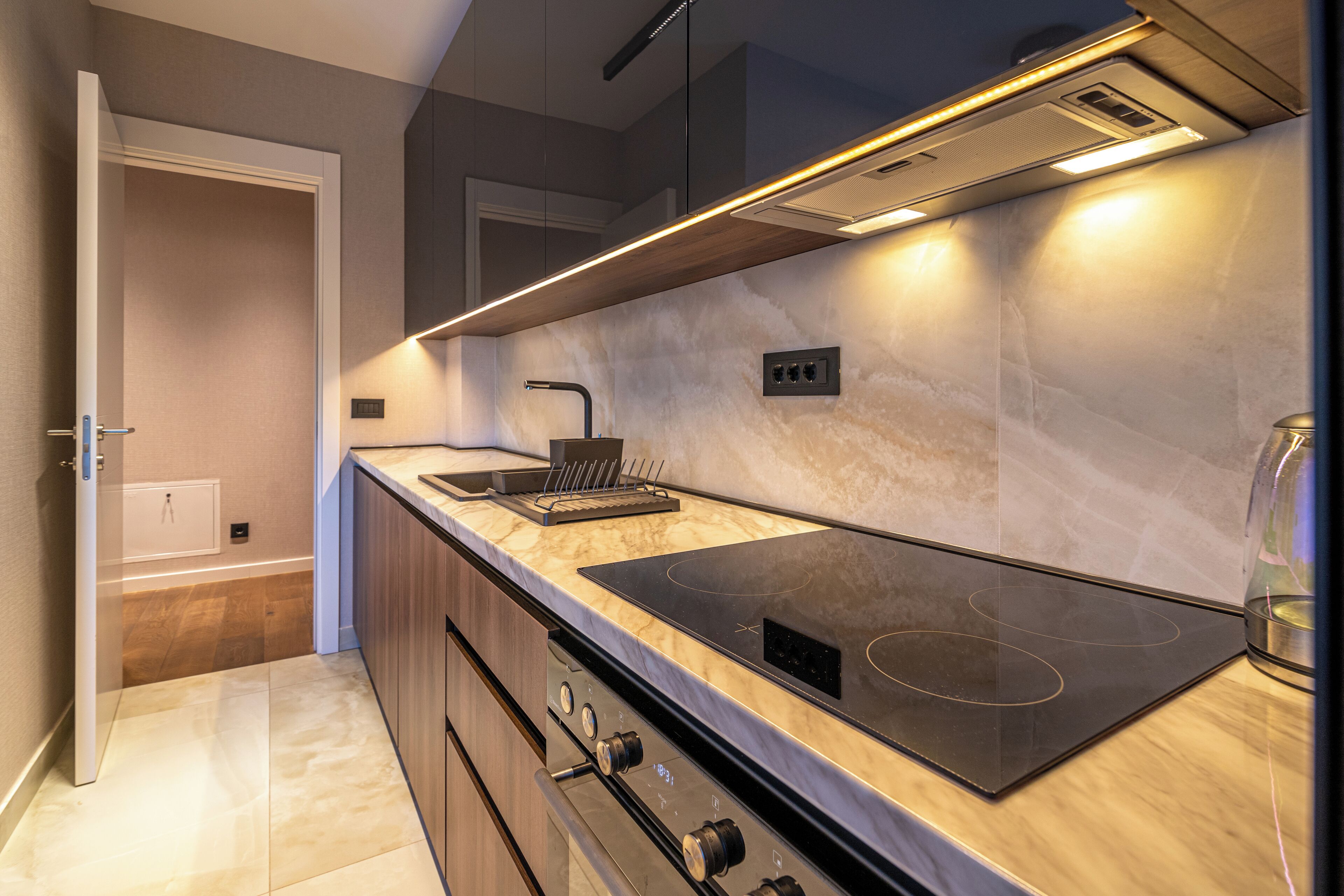 Une cuisine moderne dotée d’une cuisinière et d’un four intégrés, ainsi que d’un revêtement mural en carreaux de marbre.