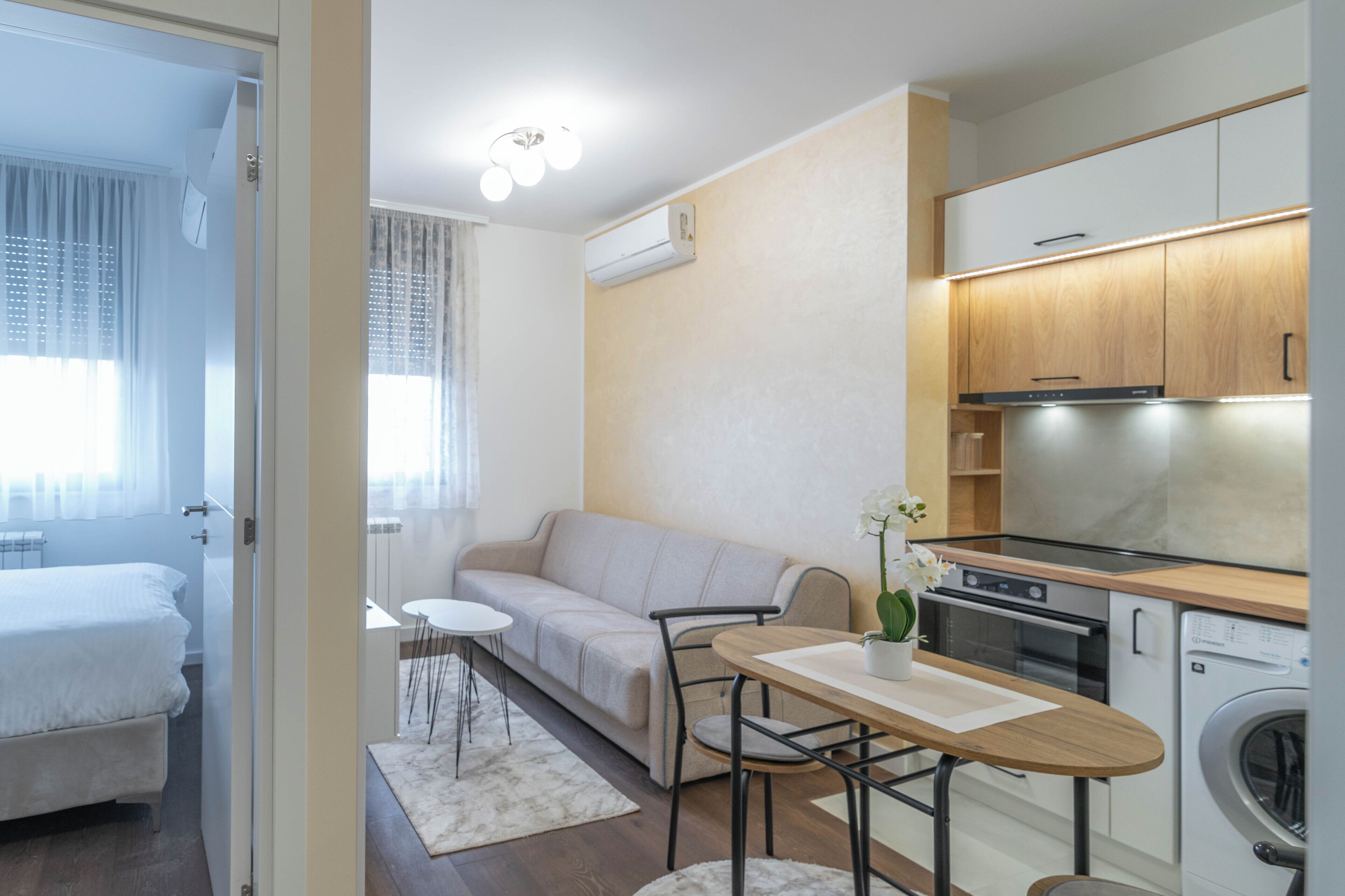 A compact living space with a kitchenette, a dining area, and a bedroom.