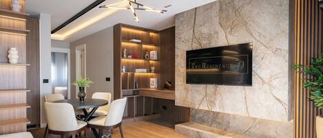 A modern living room with a fireplace, wooden shelving, and a dining area.