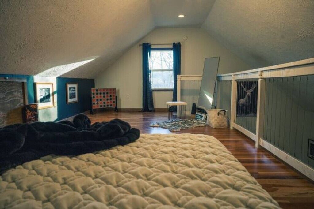 Ein Schlafzimmer mit einem großen Bett, einem Fenster und einer Heizung.