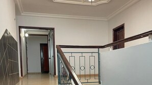 Una escalera con baldosas blanco y negro, barandilla de madera y un candelabro.