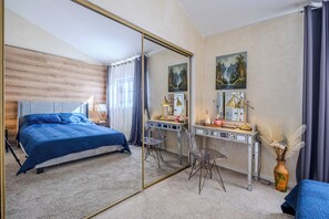 Un dormitorio con una cama grande, un escritorio y un espejo.
