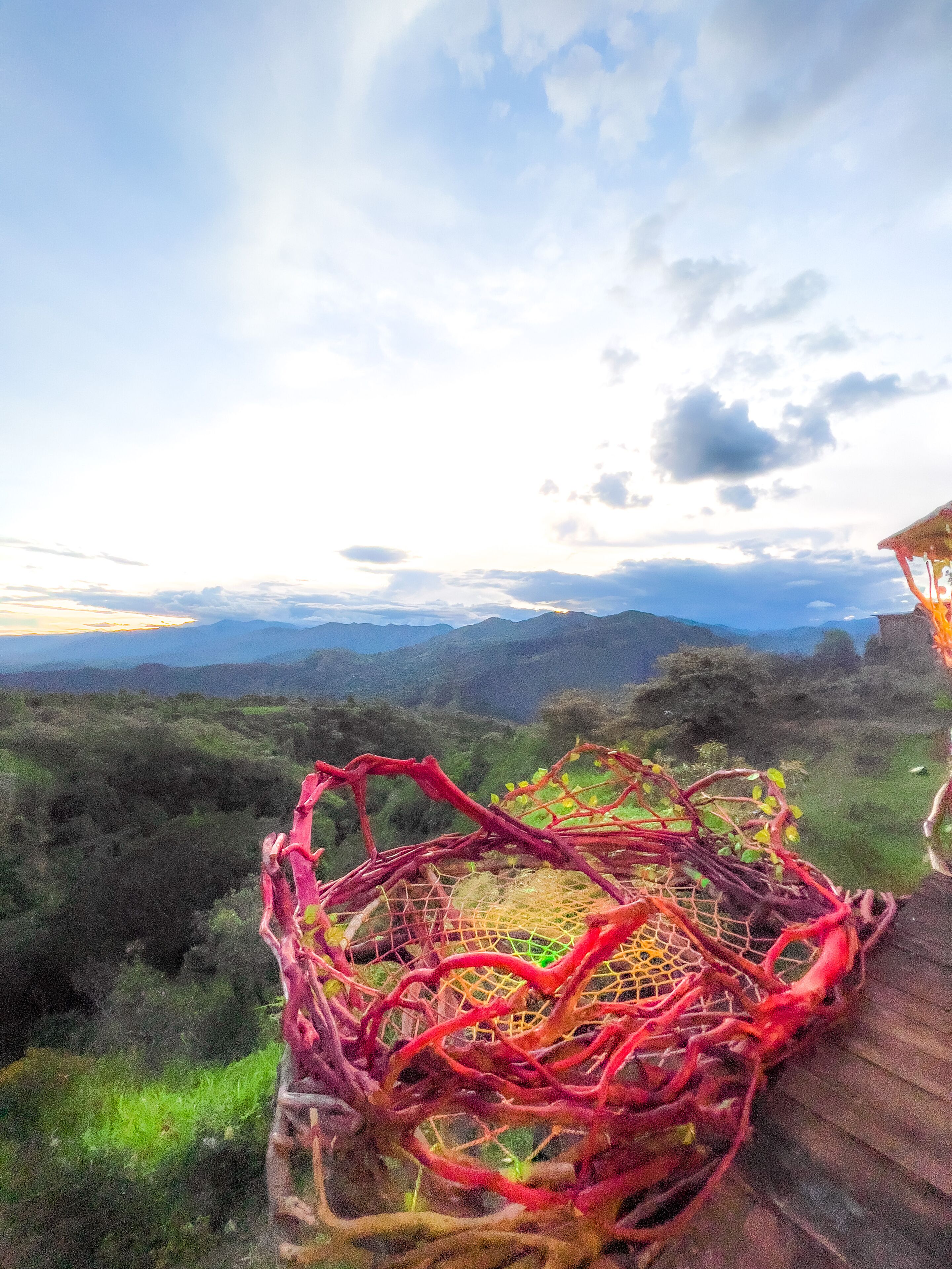 Une vue d’un paysage montagneux, avec une structure en bois au premier plan.