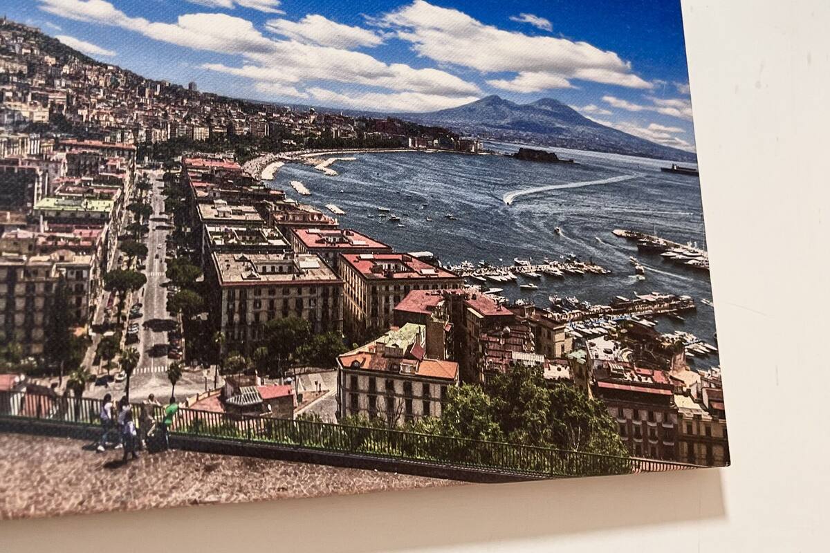A coastal cityscape with buildings, a beach, and a mountain in the background.