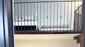 A bedroom with a bunk bed, a bed with a headboard, a bedside table, and a small white cabinet. - House Caracciolo (Naples)