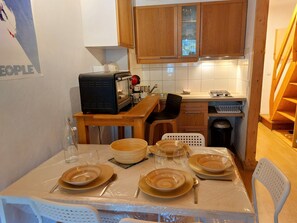 Enjoy a convenient meal at the dining table, equipped with plates, bowls, and cutlery.