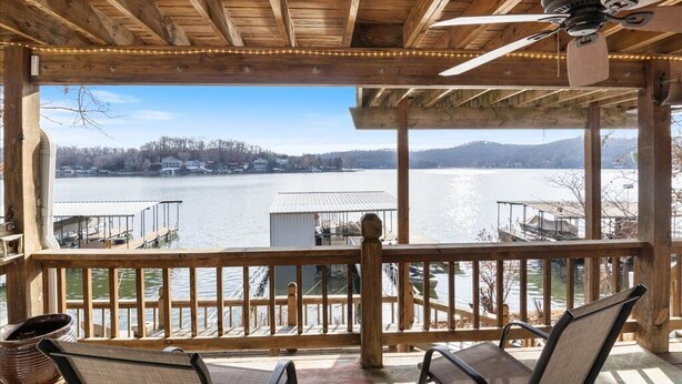 Eine Holzterrasse mit Blick auf einen See und Häuser im Hintergrund.