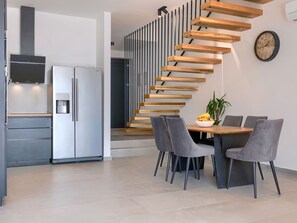 A modern kitchen with a built-in Samsung refrigerator, a water dispenser, and a sleek stove.