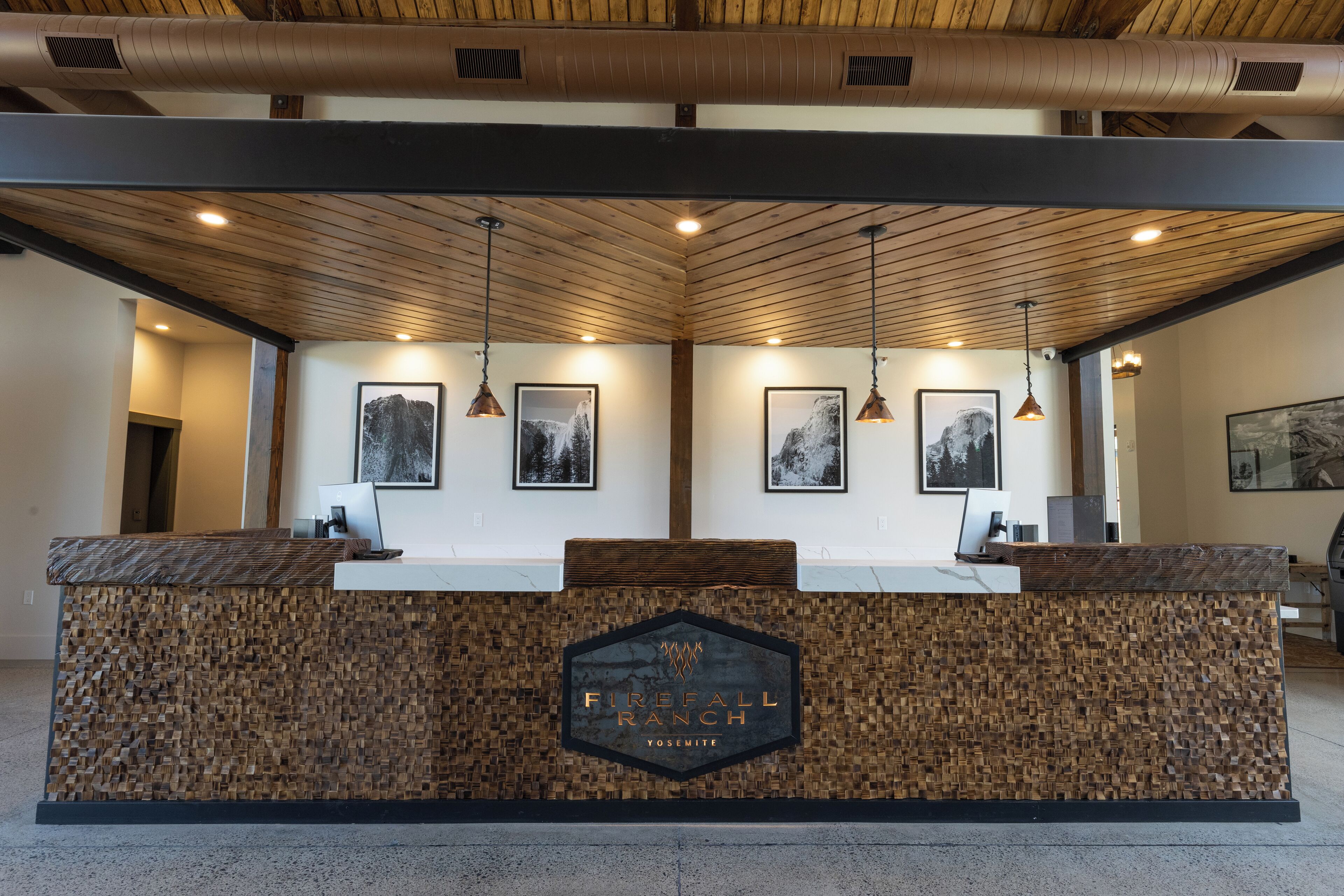 Mostrador de recepción con diseño de madera y un letrero que dice "Firefall Ranch Yosemite".