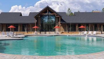 Una piscina al aire libre, camas de piscina gratis, sombrillas