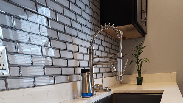 A kitchen with a white marble countertop, a stainless steel faucet, and a black sink. - Spacious and luxurious 3-bedroom home w/jetted bathtub (Worcester)