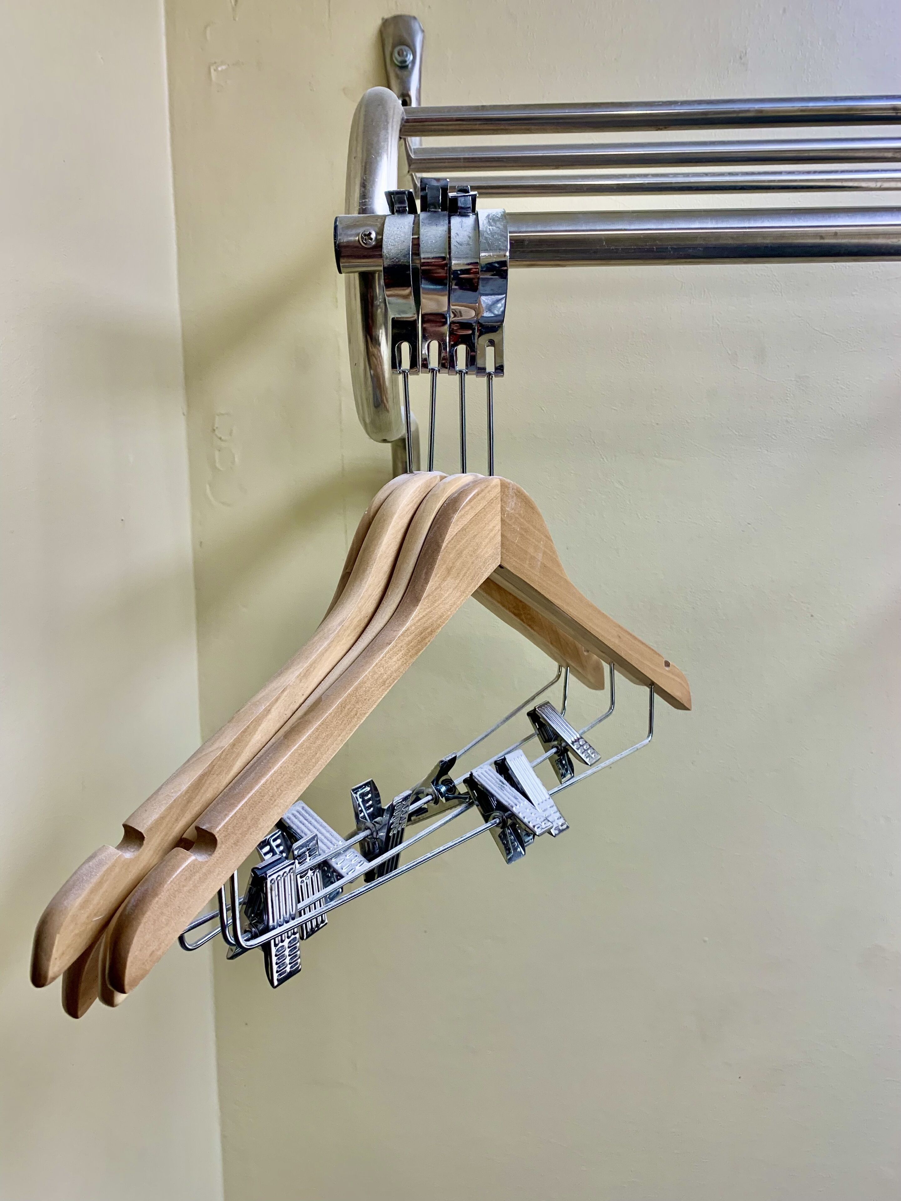 Un cintre en bois fixé à une structure métallique à l’aide d’un système de serrage.