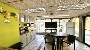 Une cuisine compacte avec un coin repas, un téléviseur et une plaque signalétique indiquant le nom de Paul Singal, directeur général.